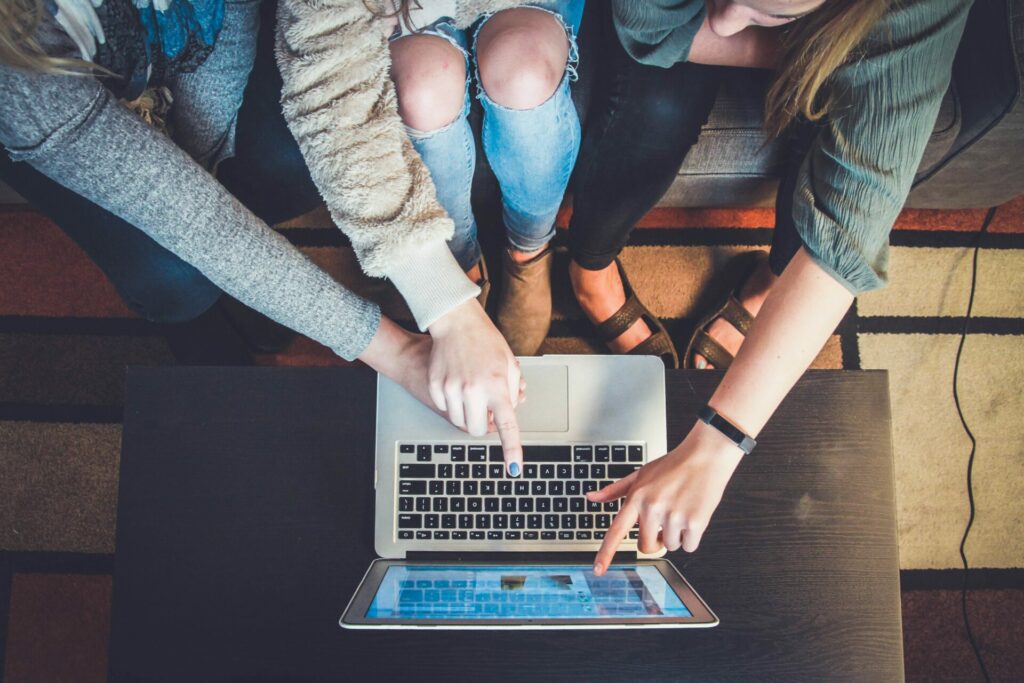 people pointing at a computer screen